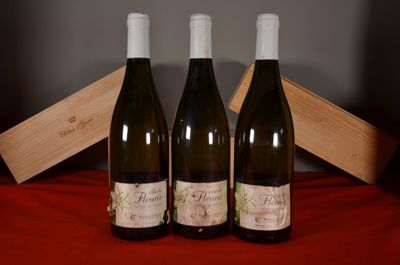 three bottles of wine sitting on a red cloth next to a wooden box