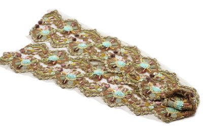 un gros plan sur un morceau de dentelle posé sur une surface blanche