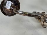 a silver object on a white table with a tag on it