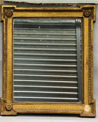 un miroir ancien dans un cadre doré, orné d'un volet métallique au milieu