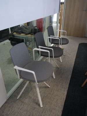 Plusieurs chaises sont alignées en rang dans un bureau.