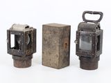 two old fashioned lanterns sitting next to each other on a white surface