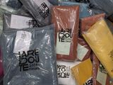 many bags of clothes that are wrapped in plastic