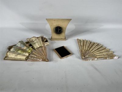 une petite horloge et beaucoup d'argent posés sur une table