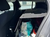 a car with the back door open with a lot of items in it