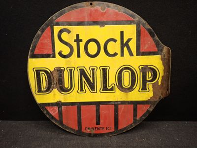 une vieille enseigne Dunlop posée sur une table noire