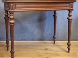 une petite table avec un plateau en bois sur un plancher en bois