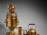 a gold plated tea set with a kettle and a teapot