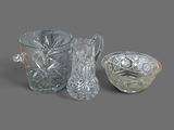 trois vases en verre et un bol posés sur une surface grise