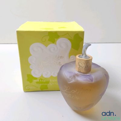 une photo montrant un flacon de parfum posé à côté d'une boîte sur une table