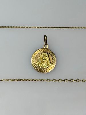 a close up of a gold coin on a gold chain