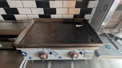 a stove top with two burners on it in a kitchen