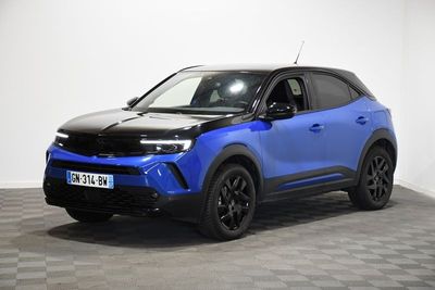 un SUV bleu garé sur un sol à damier dans une pièce