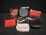 several different purses are lined up on a black surface