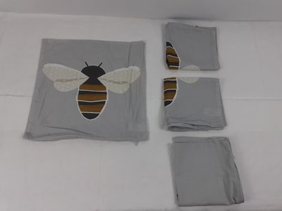 trois morceaux de tissu sur lesquels est représentée une abeille, posés sur un lit
