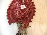 un vase rouge accroché au mur, sur lequel est accrochée une étiquette