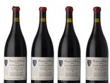 three bottles of red wine sit next to each other on a white surface