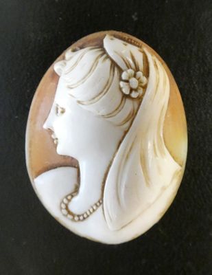 Un badge représente une femme avec une fleur dans les cheveux
