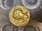 une pièce d'or posée sur une plaque métallique