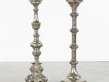 pair of silver candlesticks with ornate designs on each side