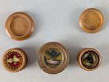 four small wooden objects on a white surface