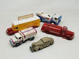 Plusieurs petites voitures et camions sont alignés sur une surface blanche