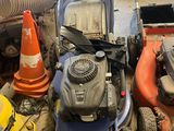 a lawn mower sitting on the ground next to other lawn mowers