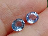 une paire de topazes bleues ornant le doigt d'une personne