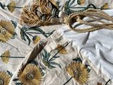 an image of a bed with a white and yellow floral comforter