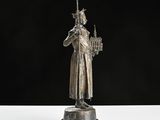a silver statue of a man holding a sword and a candle
