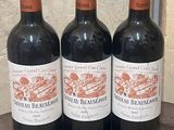 three bottles of wine sitting on top of a wooden table