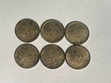 six old british coins are arranged in a row on a white surface