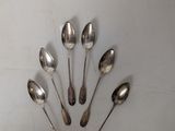 several spoons are arranged in a circle on a white surface