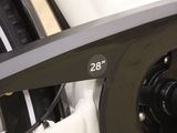 a close up of a bike chain with a bicycle in the background