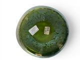 a green vase with a tag on it sitting on a white surface