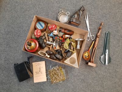 une boîte remplie d'objets hétéroclites posée sur le sol