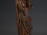 a carved wooden statue of an angel holding a child