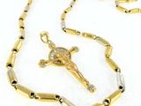 a close up of a cross on a chain on a white surface