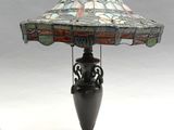 lampe avec un abat-jour en vitrail posé sur un pied en métal