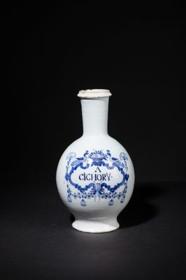 a blue and white vase sitting on a black surface