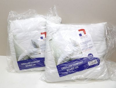 deux sacs contenant des oreillers blancs posés sur un comptoir