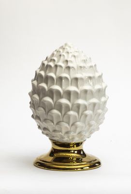 un vase blanc avec un socle doré sur fond blanc