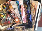 a pile of paintings on a table next to a clock