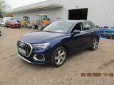 Le SUV Audi bleu est garé devant un immeuble.