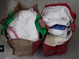two bags of clothing sitting on the floor next to each other