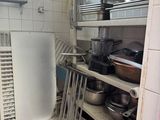 many pots and pans on the shelves in the kitchen