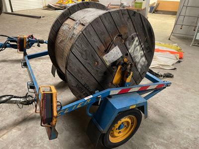 an image of a large wooden cable reel on a trailer