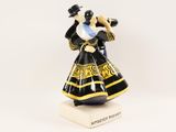 a close up of a figurine of a woman in a black and gold dress