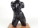 sculpture représentant un torse féminin sur un socle en marbre, sur fond blanc