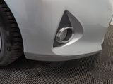 the front end of a white car with a small exhaust pipe on it
